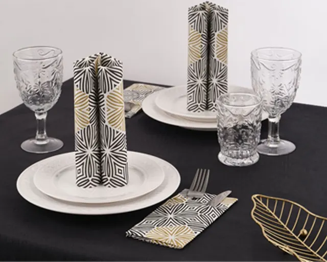 Mantel negro con servilletas de estampado dorado