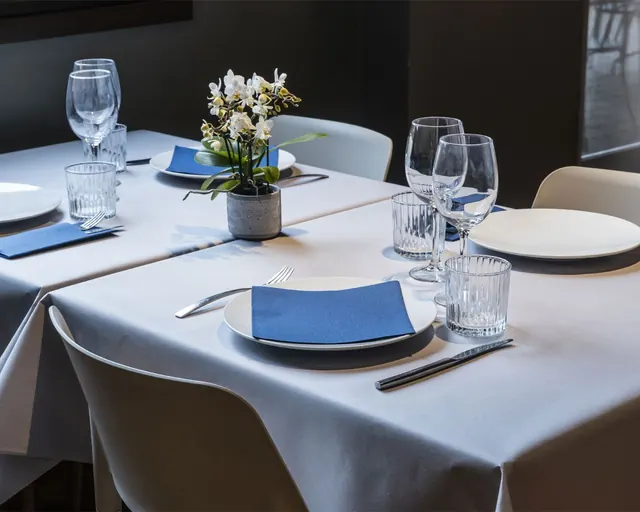 Comedor de restaurante con manteles blancos y servilletas azules