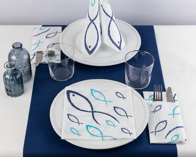 Servilletas decoradas con peces sobre camino azul marino